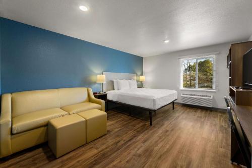 纽波特纽斯WoodSpring Suites Yorktown Newport News的酒店客房,配有床和沙发
