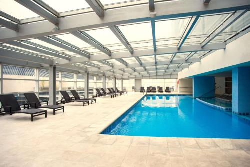 门多萨Hilton Mendoza的大楼内带椅子的大型游泳池