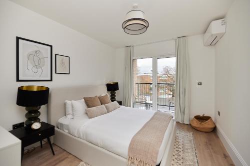 伦敦The Wembley Park Sanctuary - Stunning 2BDR Flat with Balcony的白色的卧室设有床和窗户