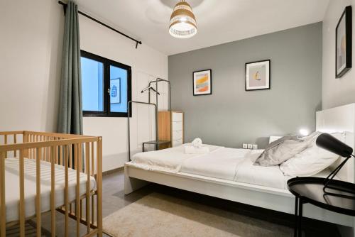 里尔4 bedroom apartment with parking !的一间卧室配有一张床和一张婴儿床