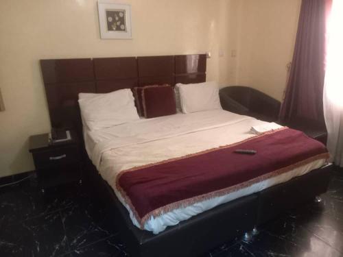 奥韦里The Resident Hotel的一间卧室配有一张大床和木制床头板