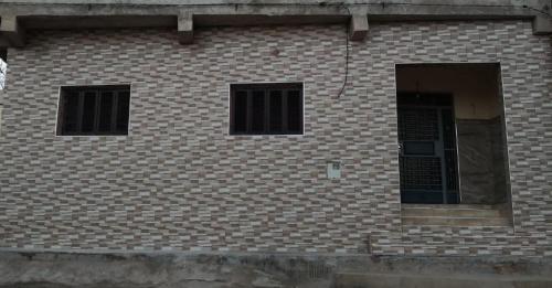 SelouaneFamily house 2 bedrooms, 2 sdb, near Center of Nador & Airport的砖砌建筑,设有两扇窗户和一扇门