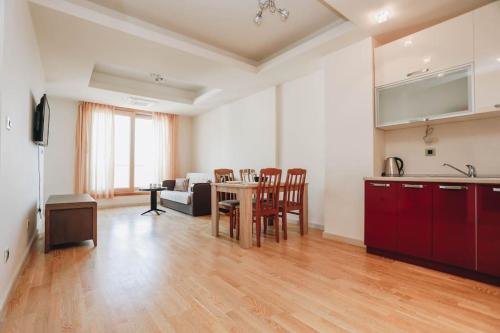 布德瓦Spacious apartment in a center of Budva的厨房以及带桌椅的起居室。