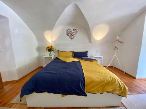 瓜尔达Engadin Holidays ch - Chasa 32 in Guarda的一间卧室配有一张黄色和蓝色的被子。