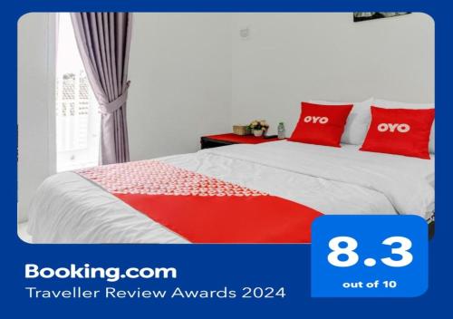 图隆阿贡Super OYO 90730 Padekosan的一间卧室配有一张带两个红色枕头的床