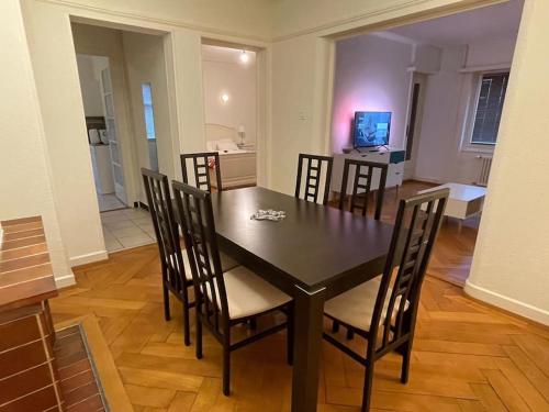 洛桑Appartement élégant & ensoleillé的客厅配有餐桌和椅子
