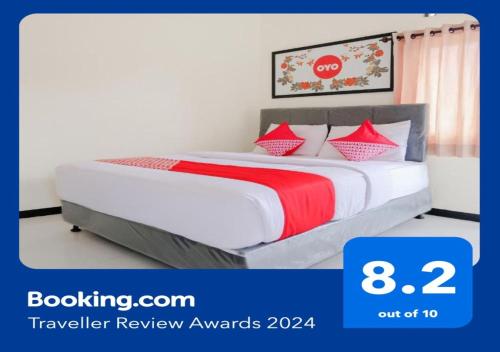 巴图OYO 894 Nusa Indah Homestay Syariah的一间卧室配有红色和白色枕头的床