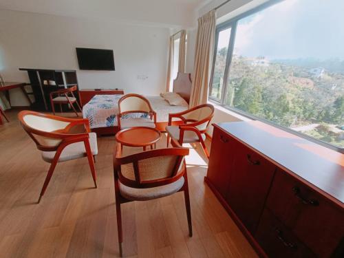 科代卡纳尔RS Family Stay的一间带桌椅的房间和一间卧室