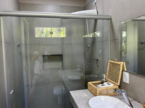 巴西利亚Casa da 17 - Lago Sul的一间带玻璃淋浴和水槽的浴室