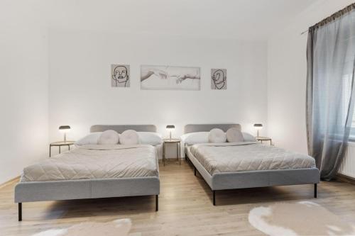 布拉迪斯拉发City Center Suite - Modern & Stylish的白色客房的两张床,配有两盏灯