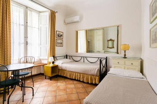 罗马斯皮恩尼套房住宿加早餐旅馆的一间卧室配有一张床、一张桌子和一面镜子