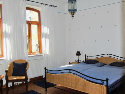 策勒Gästehaus EinsA的一间卧室配有一张床和一把椅子