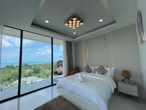 茶云莱海滩Villa Savoy Sharm Samui的卧室设有白色的床和大窗户