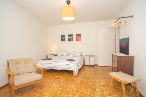 巴塞尔Modern 3-bedroom apartment in city centre的一间卧室配有一张床和一把椅子