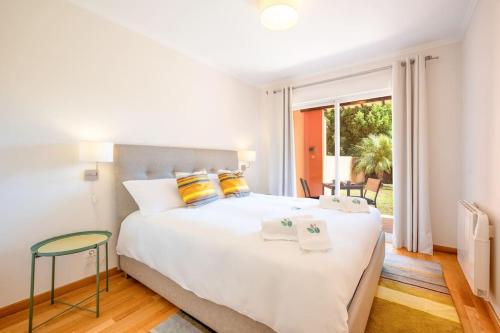 AroeiraCasa do Jardim- Aroeira的卧室配有一张带黄色枕头的大型白色床。