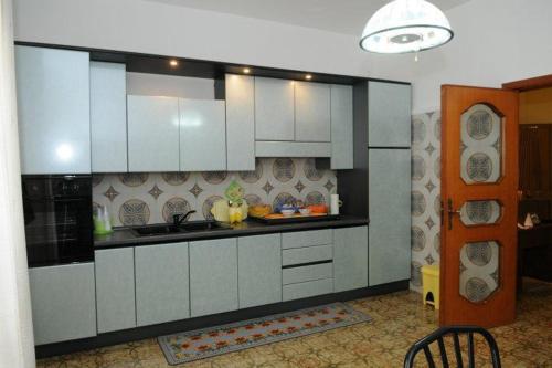 梅萨涅I Messapi的厨房配有白色橱柜和水槽