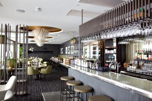 阿兰达Clarion Hotel Arlanda Airport Terminal的餐厅设有带凳子的酒吧