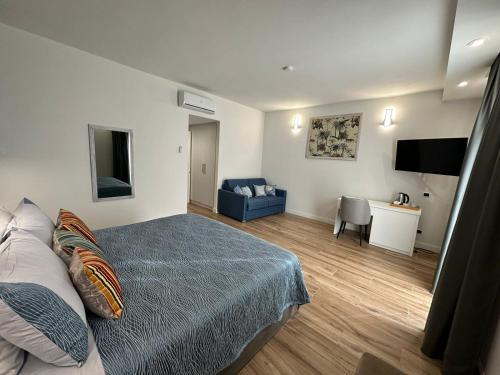 莱什Evergreen Laguna Vain-Lezhe的一间卧室配有一张床、一张沙发和一台电视