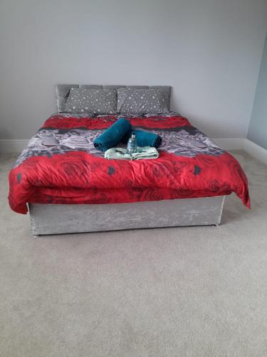 诺丁汉Luxurious New Build的一张带红色毯子和蓝色枕头的床