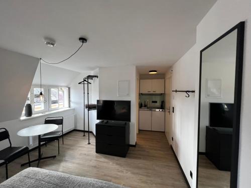 布克斯泰胡德Studiowohnung 6 in Buxtehude的客厅配有电视、桌子和镜子