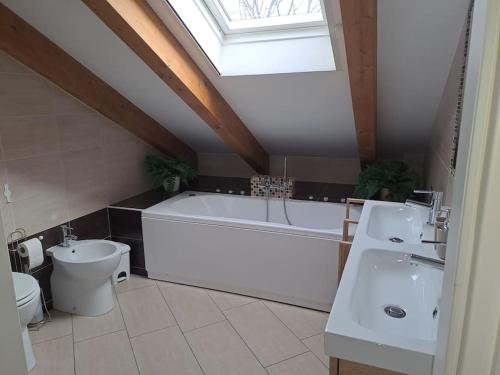 都灵Casa Poli的浴室配有白色浴缸、卫生间和水槽。