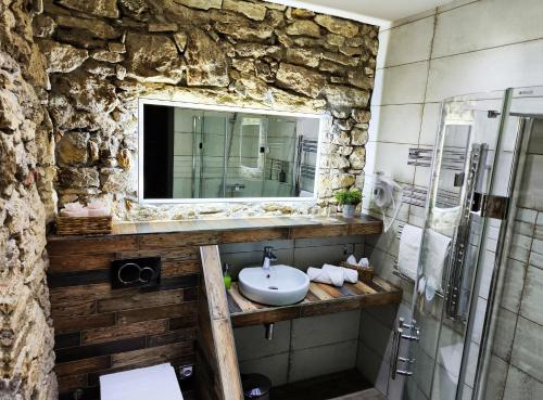 Liptovská TepláLiptovský mlyn的石质浴室设有水槽和镜子