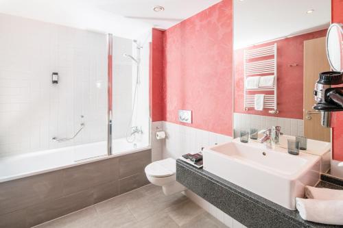 柏林柏灵阿巴巴酒店的浴室配有盥洗盆、卫生间和浴缸。