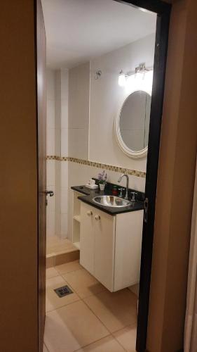 孙查莱斯MODERNO MONOAMBIENTE CALIDAD SUPERIOR的一间带水槽和镜子的小浴室