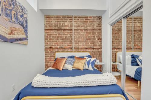 萨凡纳Lush Savannah Loft - Near Plant Riverside District的一间卧室设有一张床和砖墙