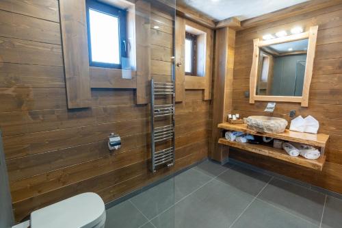 韦林格勒V Chalet Residence的浴室设有木墙、水槽和镜子