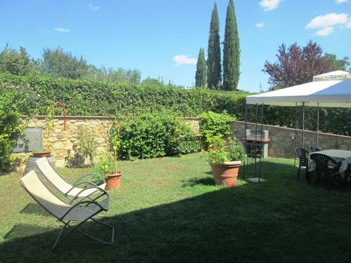 波吉邦西Casa ai Carfini的一个带椅子、桌子和雨伞的院子