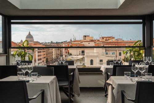 罗马21酒店的一间带桌椅的市景餐厅