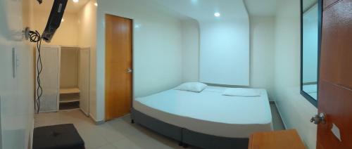 波哥大AW Connect Airport的一间小卧室,配有一张白色的床和一个衣柜
