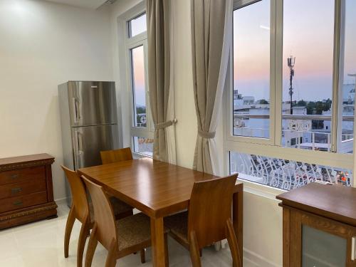 朱笃Paris Hotel Châu Đốc的厨房配有木桌和冰箱。