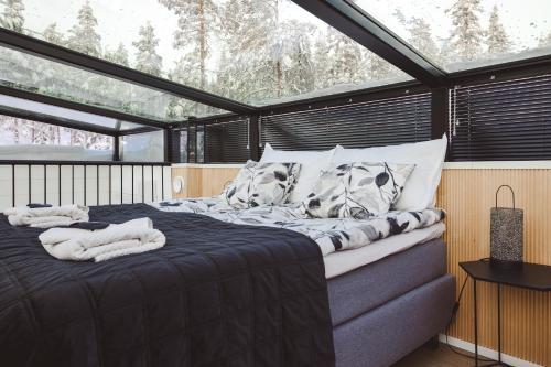 锡尔卡Glass Ceiling Suite Kipinä的卧室在窗户前配有一张大床