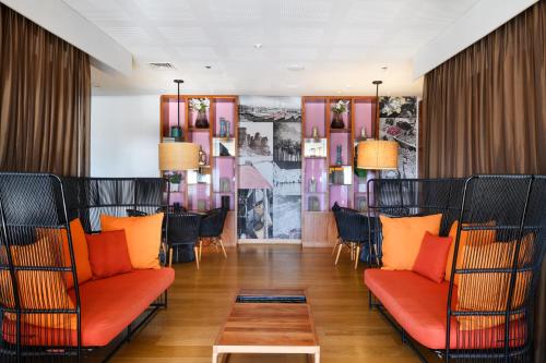 恩波其克Noga by Isrotel Collection - The Renewed Ganim Hotel的一间设有橙色椅子和桌子的餐厅