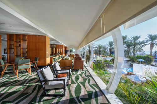 恩波其克Noga by Isrotel Collection - The Renewed Ganim Hotel的大堂享有大海和棕榈树的景致。