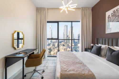 迪拜Silkhaus Burj Khalifa view large 2BDR in new tower的一间卧室配有一张大床、一张桌子和一个窗户。