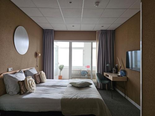 弗利辛恩索尔斯金餐厅酒店的酒店客房配有一张床、一张书桌和一台电视。