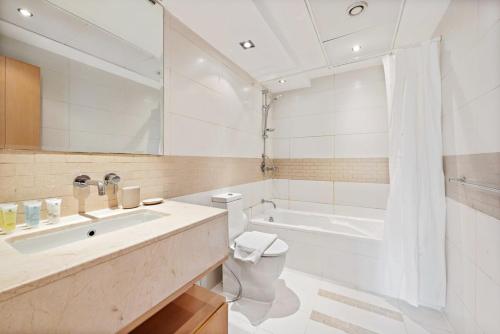 迪拜Silkhaus Modern 1BDR in Marina Close to Beach的浴室配有盥洗盆、卫生间和浴缸。