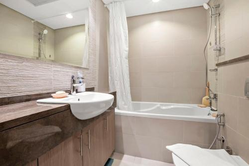 阿布扎比Silkhaus Luxury studio in Saadiyat Island的浴室配有盥洗盆和浴缸。