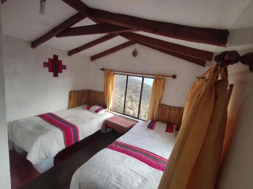 Comunidad YumaniINTI WASI LODGE的一间卧室设有两张单人床和一个窗户。