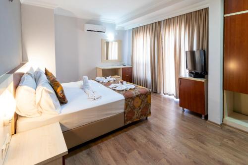 安塔利亚拉拉迪恩克酒店的酒店客房,配有床和电视