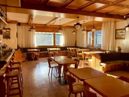 圣维托-迪卡多雷欧斯酒店的一间带桌椅的餐厅和一间酒吧