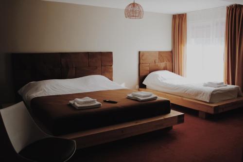 NăsăudPopasul Graniceresc的一间卧室设有两张床、一把椅子和一个窗户。