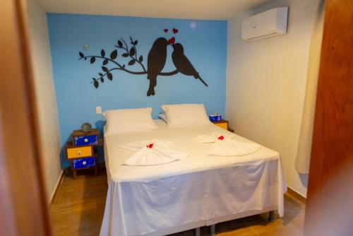 Serra de São BentoVila Feliz - Chalés completos - ideal para famílias的卧室配有一张床铺,墙上有两只鸟