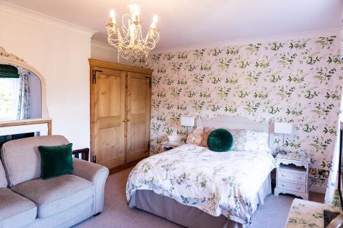 布由德利Kateshill House Bed & Breakfast的一间卧室配有一张床、一把椅子和一个吊灯。