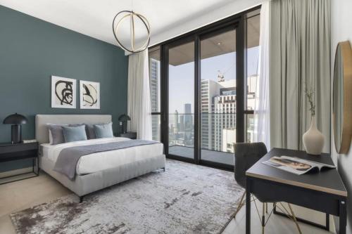 迪拜Silkhaus homely 2BDR with stunning Downtown view with Balcony的一间卧室配有一张床、一张书桌和一个大窗户