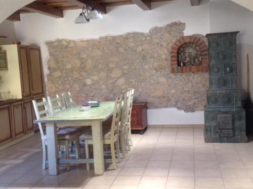 米库洛夫Lormův dvůr的厨房配有桌椅和石制壁炉。