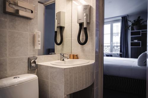 巴黎Hôtel de Charonne的一间带水槽和卫生间的浴室以及一张床
